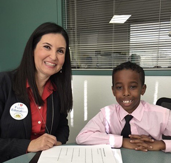 Dr. Lupita Hightower with a young black male student